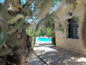 A stone pathway leading to a pool area with a stone building on the right. - Villa Elia is situated in a quiet area, surrounded by olive trees with a private (Πιτσίδια)