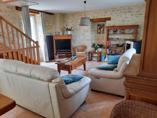 A living room with a sofa, a coffee table, a TV, and a bookshelf.