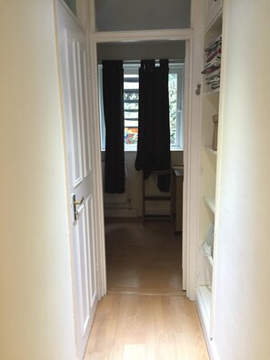 Enter a cozy room with a window and a comfortable space to unwind.