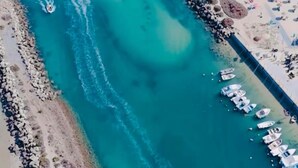 An aerial view of a coastal area with a sandy beach, a rocky shoreline, and a marina with boats. -  Portugal Private Villa with private pool rural quiet tranquil setting (moncaropacho)