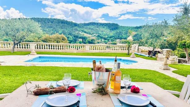 A table set for two with a view of a swimming pool and a mountainous landscape. - Villa, private swimming pool exclusive to tenants (Cabasse)