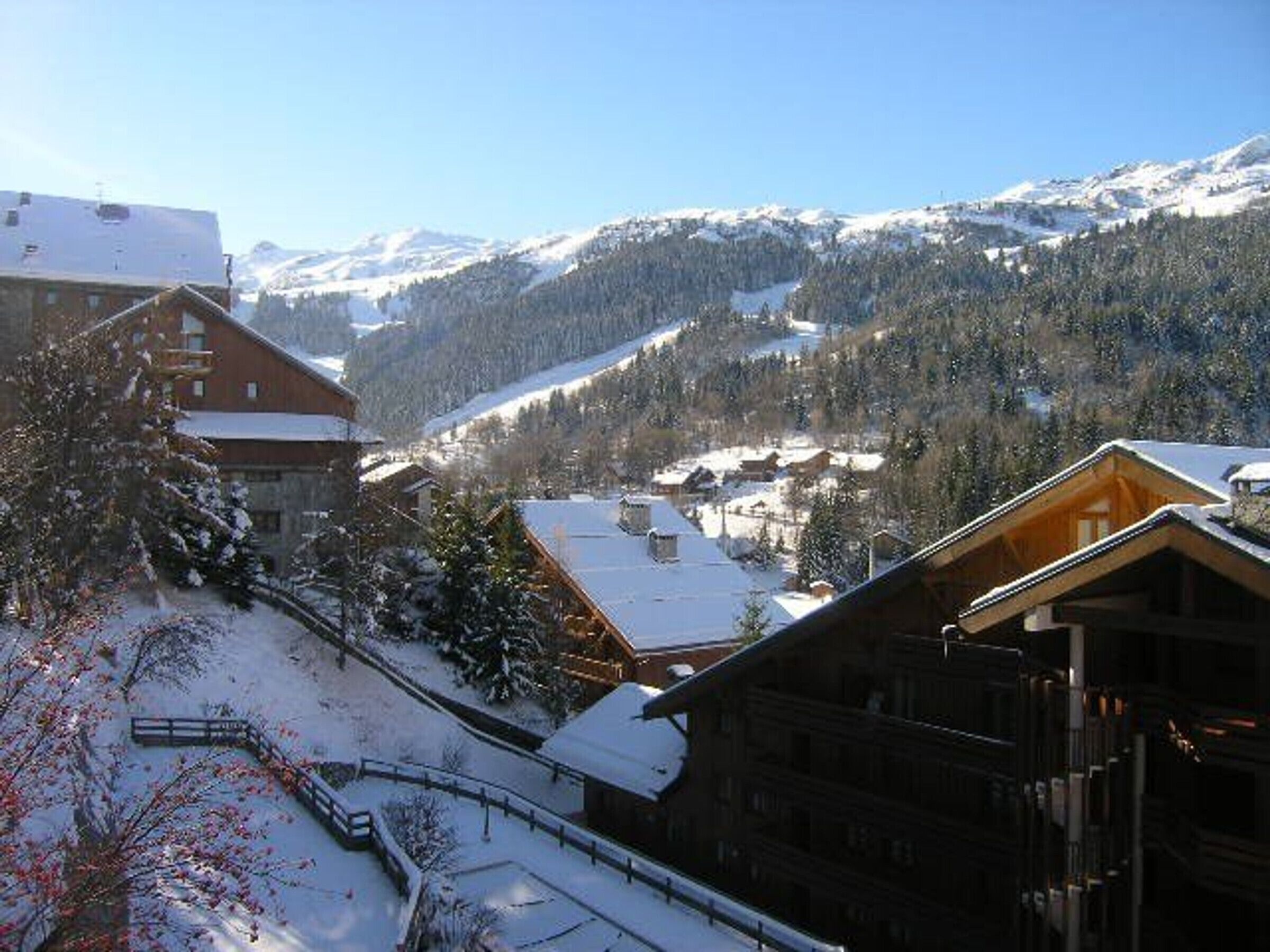 A snow-covered mountain village with wooden buildings and a ski slope.