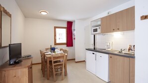 A compact kitchen with wooden cabinets, a microwave, and a dishwasher. - Balcons C 023 - PARC NAT. VANOISE appart. 6 pers. (Val Cenis)
