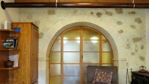 Uma sala de estar aconchegante com lareira, um aparador de madeira e um sofá com almofada colorida.