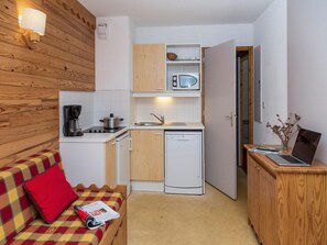 A compact kitchen with a coffee maker, microwave, sink, and dishwasher. - Chalet in France with Balcony and Natural Charm (Valmeinier)