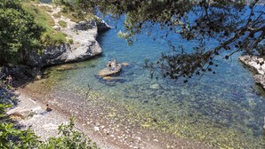 A clear coastal area with rocky shores and a view of distant mountains. - Apartment in Corsica near Beaches (Oletta)