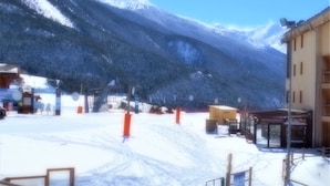 A snow-covered mountain landscape with a building that has a sign reading "Restaurant Escalier".