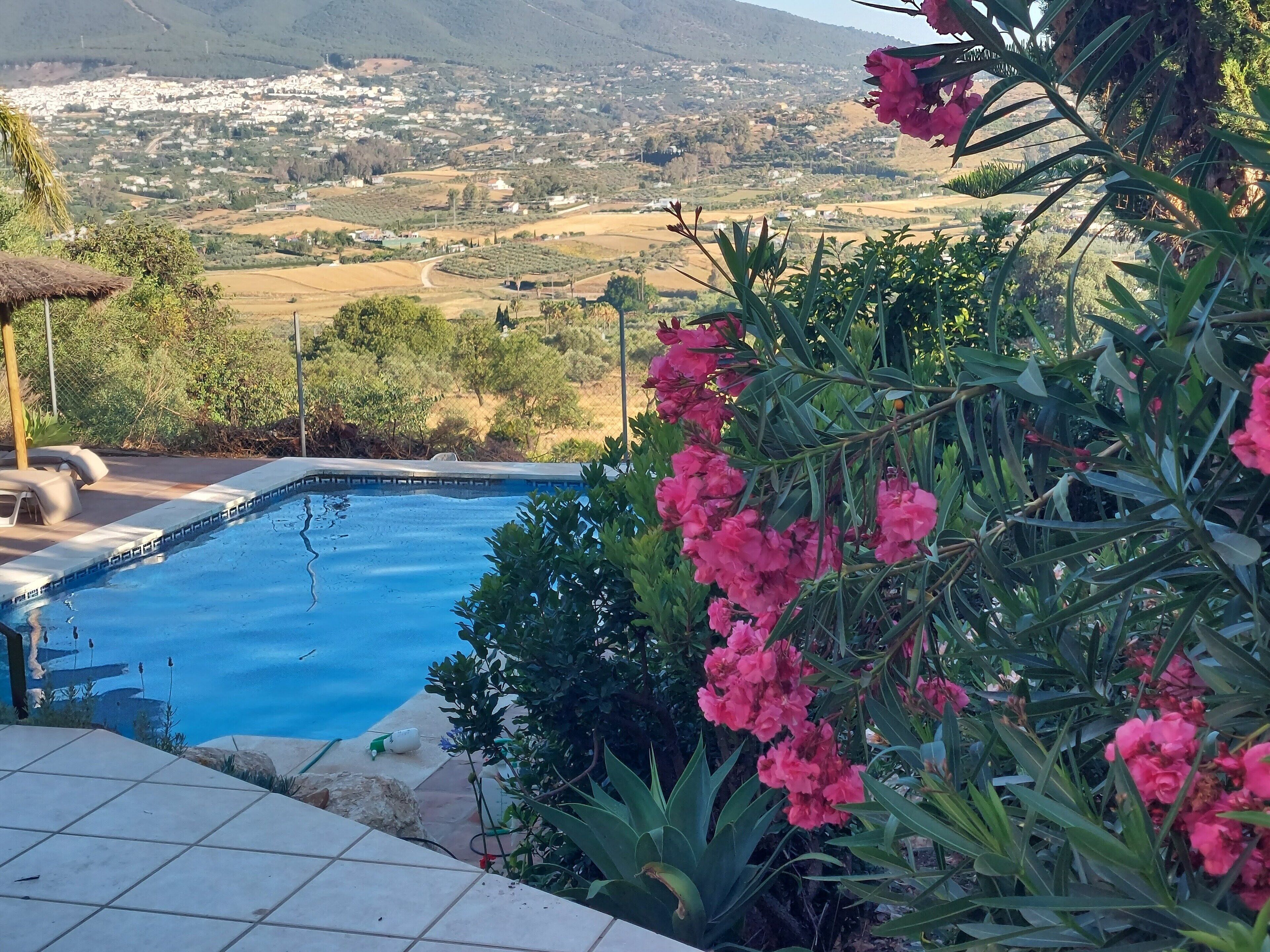 Una piscina con vistas a un pueblo y montañas al fondo.