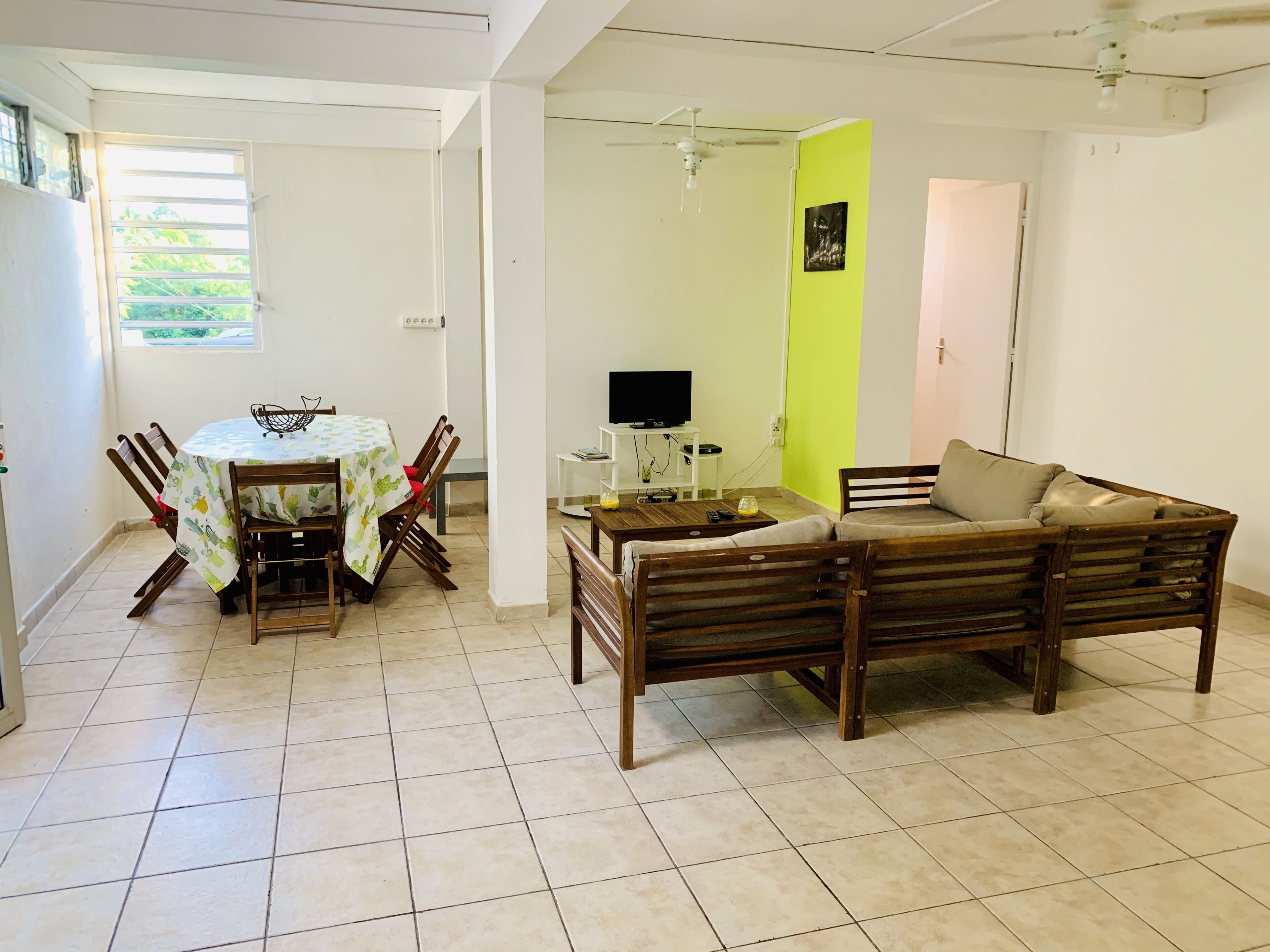 Un salon comprenant un coin repas, un canapé, un téléviseur et une table avec des chaises.