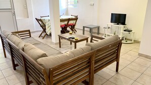 Uma sala de estar com sofá, mesa de centro e rack para televisão.