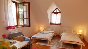 Un dormitorio acogedor con dos camas, un escritorio y una silla.