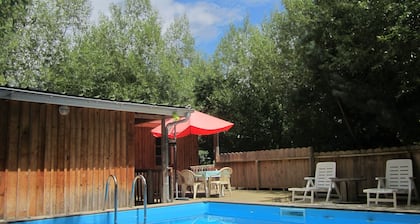 Lodge en bois avec terrasse et piscine dans un cadre verdoyant