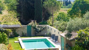 A private pool area with a stone wall, a small deck, and a chair.