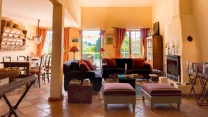 A cozy living room with a fireplace, a dining area with a buffet, and a view of the outdoors.