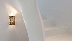 Eine weiße Treppe mit einer Wandleuchte.