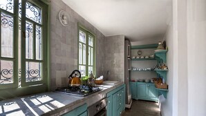 A kitchen with teal cabinets, a stove, and a refrigerator. - Beau Riad for Rent (Fès-Boulmane)