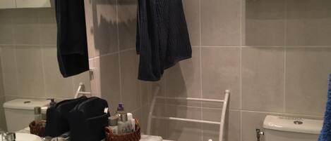 Ein Badezimmer mit Waschbecken, Toilette und Handtuchhalter.