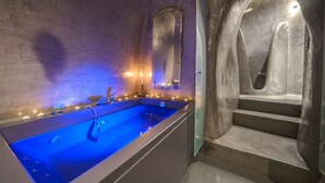 Un espace spa comprenant une grande baignoire, un miroir et un escalier menant à un niveau supérieur.
