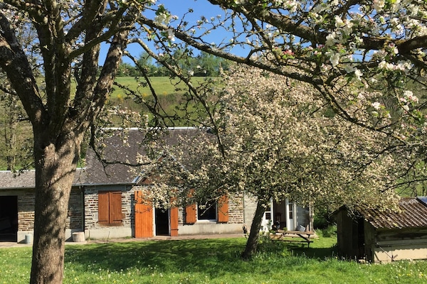 La maison aux milieu des pommiers en fleurs.
