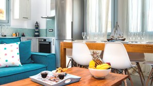 A modern kitchen with a refrigerator, sink, and dining area with chairs and a table.
