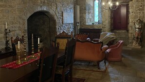 Un comedor rústico con chimenea de piedra, muebles de madera y una araña.