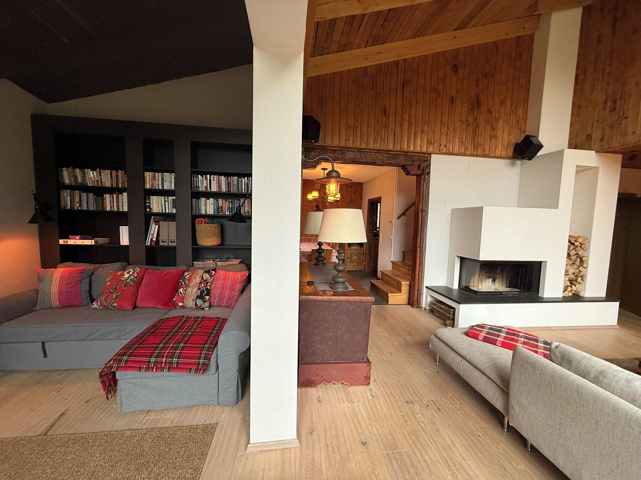 Un salon chaleureux avec une cheminée, un canapé, une bibliothèque et un coin repas.