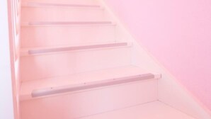 Una escalera con peldaños y barandillas blancas, que sube.