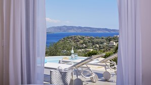 Un balcon avec une piscine, des chaises longues et une vue sur la mer et les collines.