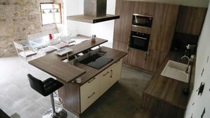 Eine moderne Küche mit einer zentralen Kochinsel, Holzschränken und integrierten Geräten.