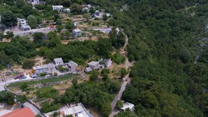 Vista aérea de una zona residencial con casas, piscina y una calle.