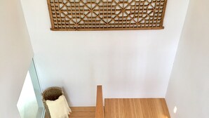 A wooden staircase with a geometric patterned wall above it.
