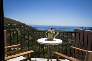 Enjoy the serene coastal view from this balcony with a table and chair.