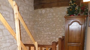 A wooden staircase with a handrail, a wooden door with a small window, and a small Christmas tree on top of a cabinet. - The Country House Mijotiere (monestier)