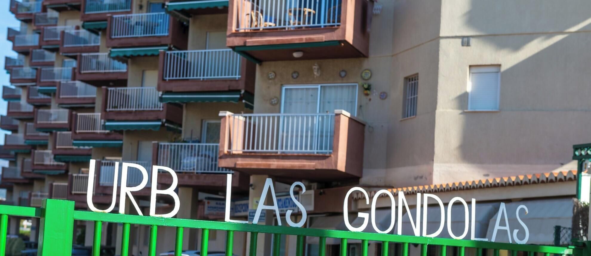 Un edificio residenziale a più piani con balconi e un cartello con la scritta "URB LAS GONDOLAS".
