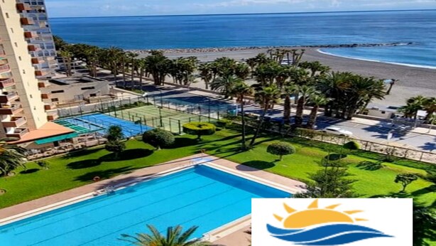 A resort with a swimming pool, beach, and ocean view.