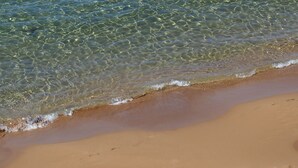 Une plage de sable fin, avec une eau claire et des vagues douces.