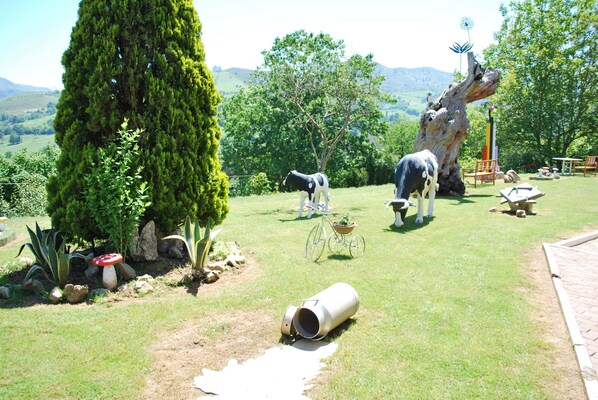 Un jardin avec des statues, un arbre et un vélo.