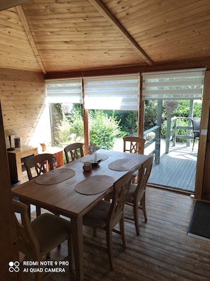 A wooden dining area with a table set for four, surrounded by chairs.