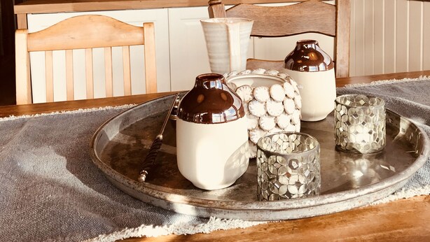 Uma cozinha acolhedora com armários de madeira, uma mesa de jantar de madeira e luminárias pendentes.