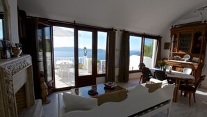 Un salon spacieux avec un grand canapé, une table à manger et une vue sur la mer.