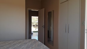Una camera da letto con un letto, un armadio e una porta che dà su uno spazio all'aperto.