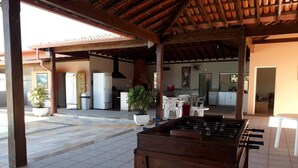 Un'area patio all'aperto con un tavolo da calcio balilla, piante in vaso e una cucina sullo sfondo.