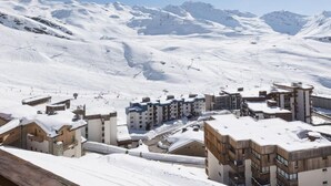 A snowy mountain town with buildings and a clear sky.
