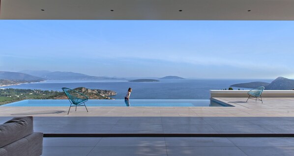 A modern outdoor terrace with a clear view of the sea and distant islands.