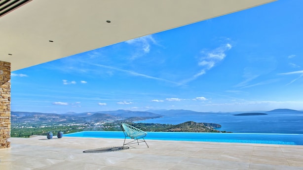 En infinitypool med en fantastisk utsikt över havet och de avlägsna bergen.