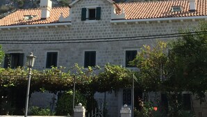 A stone building with a tiled roof, a small window, and a gate. - Exotic,sunny and peacfull (Dobrota)