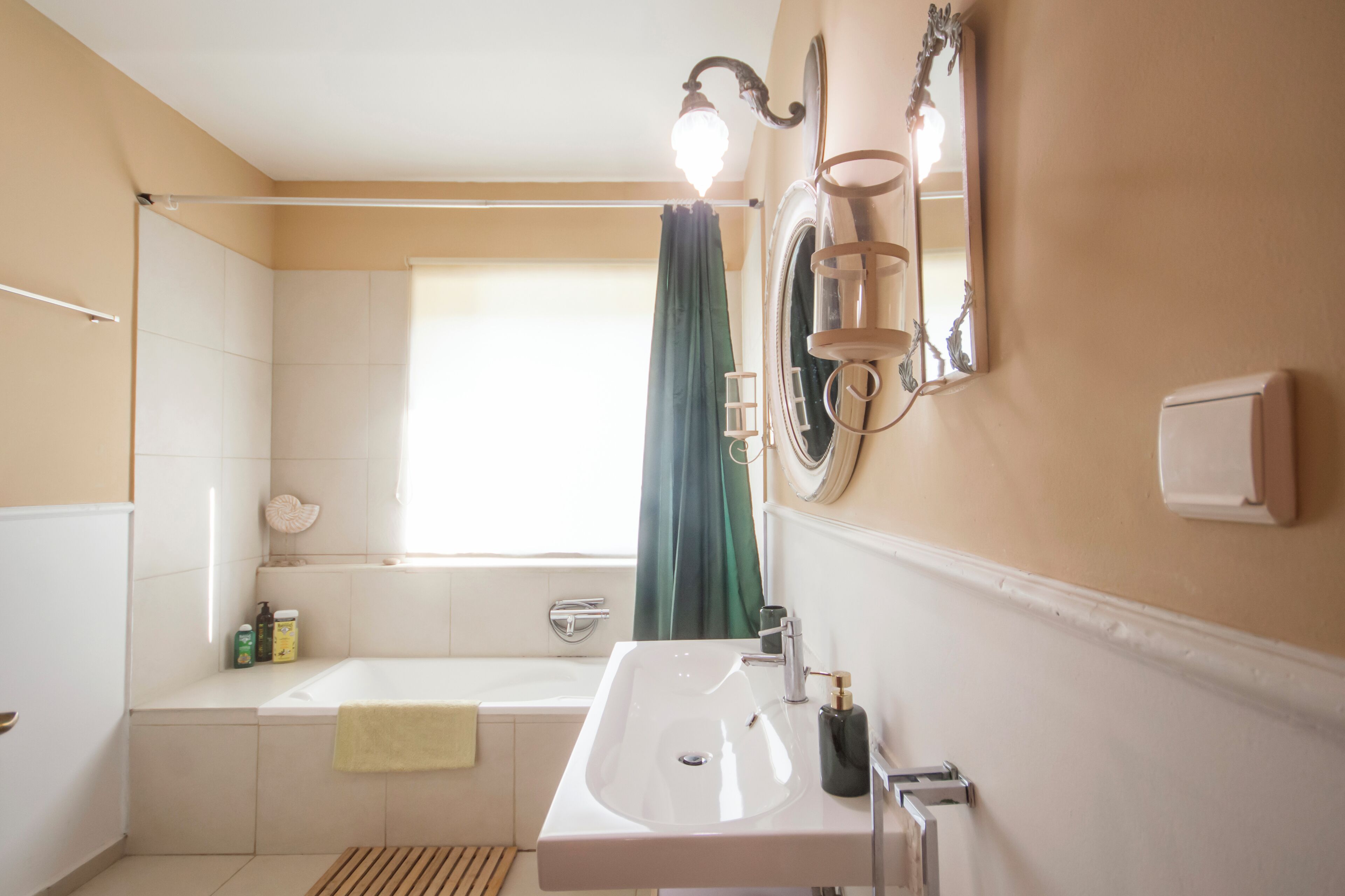 A bathroom with a bathtub, a sink, and a mirror.