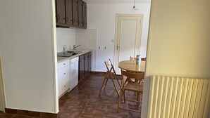 A kitchen with a sink, cabinets, and a dining area with chairs and a table. - Quiet location, ideal for relaxing, house 5 km from the beaches of Binic-Etables (Lantic)