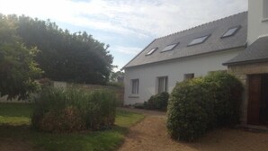 A house with a gravel driveway, a small garden with bushes, and a white exterior. - Quiet location, ideal for relaxing, house 5 km from the beaches of Binic-Etables (Lantic)