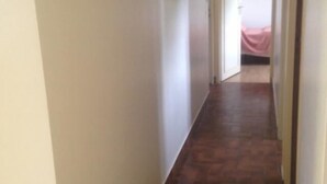 A narrow hallway with a wooden floor leading to a room with a bed. - Quiet location, ideal for relaxing, house 5 km from the beaches of Binic-Etables (Lantic)